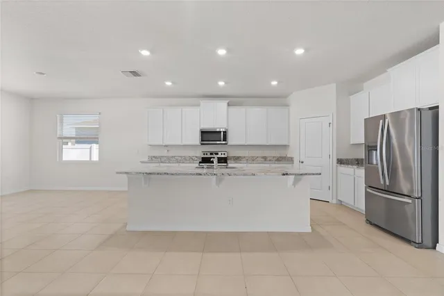 a kitchen with stainless steel appliances granite countertop a refrigerator sink and stove