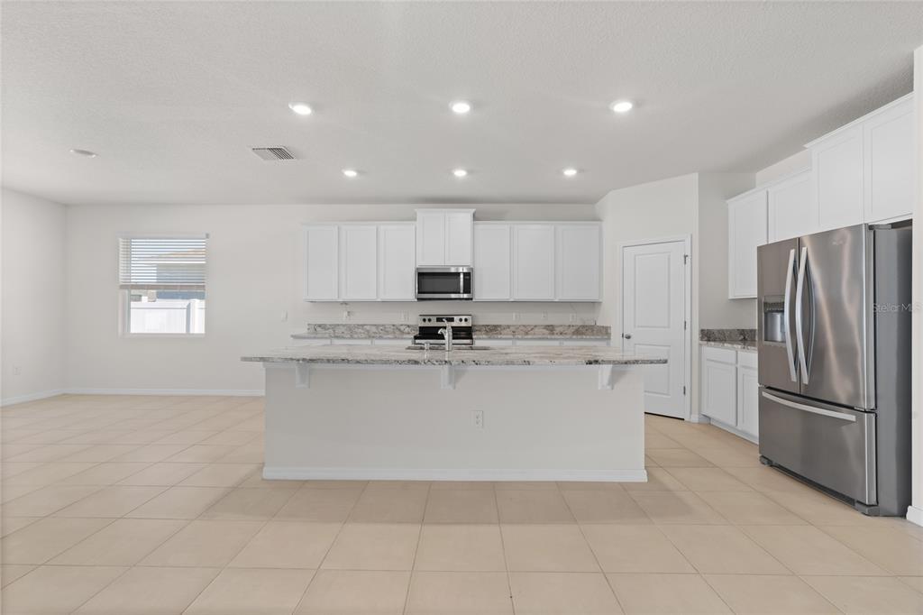 8260 Southwest 59th Avenue Ocala, FL 34476 - Photo 7 of 37 a kitchen with stainless steel appliances granite countertop a refrigerator sink and stove