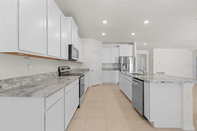 a large kitchen with stainless steel appliances granite countertop a sink and cabinets