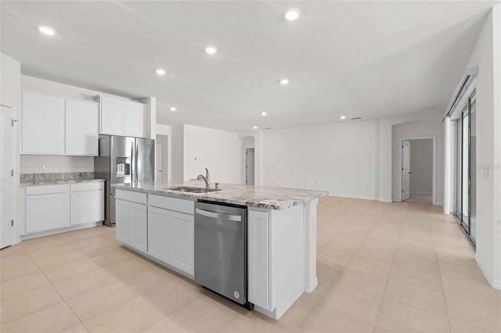 8260 Southwest 59th Avenue Ocala, FL 34476 - Photo 9 of 37 a kitchen with stainless steel appliances granite countertop a stove top oven a sink and white cabinets