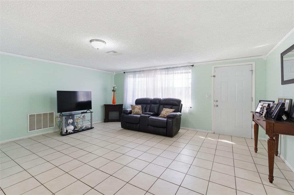 4904 Elmwood Street New Port Richey, FL 34653 - Photo 14 of 57 a living room with furniture and a flat screen tv