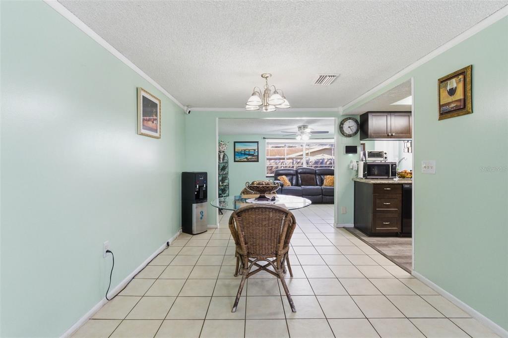 4904 Elmwood Street New Port Richey, FL 34653 - Photo 16 of 57 a living room with furniture and a chandelier