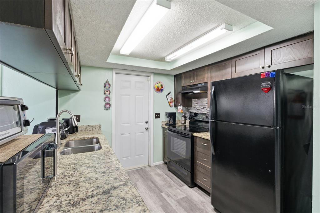 4904 Elmwood Street New Port Richey, FL 34653 - Photo 19 of 57 a kitchen with stainless steel appliances granite countertop a refrigerator a stove and a sink