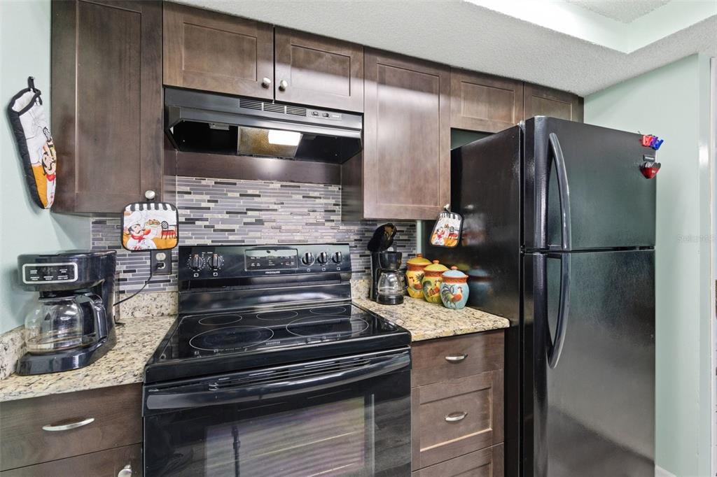 4904 Elmwood Street New Port Richey, FL 34653 - Photo 22 of 57 a kitchen with granite countertop stainless steel appliances and wooden floor