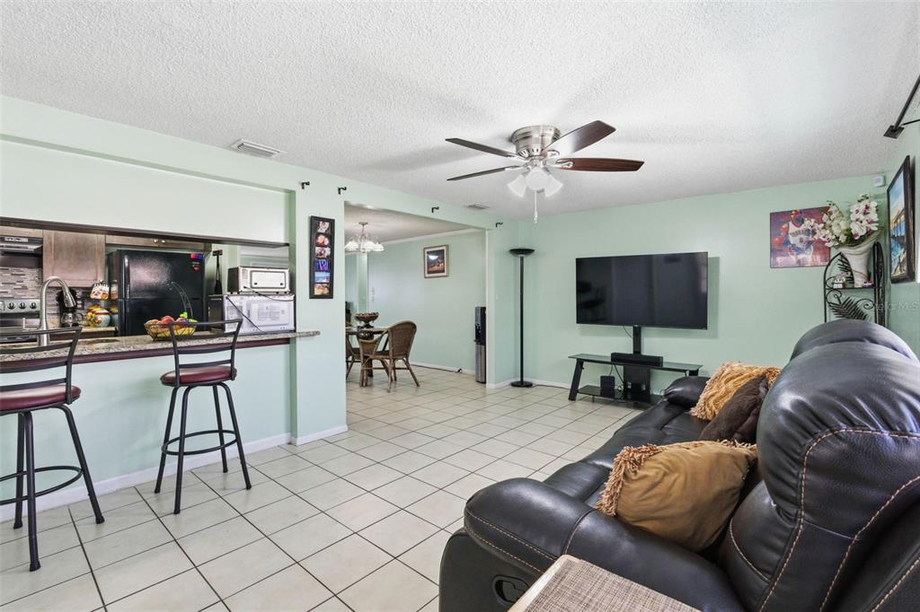 4904 Elmwood Street New Port Richey, FL 34653 - Photo 24 of 57 a living room with furniture and a flat screen tv