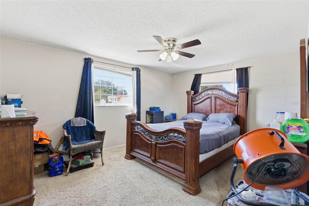 4904 Elmwood Street New Port Richey, FL 34653 - Photo 28 of 57 a bedroom with a bed and a chandelier