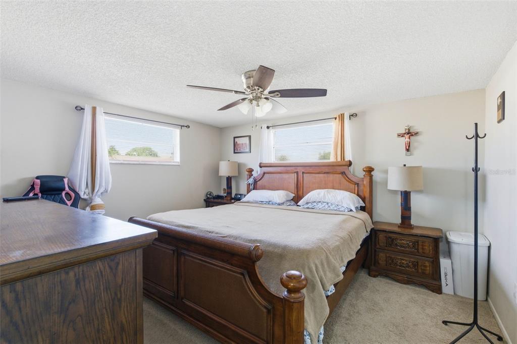 4904 Elmwood Street New Port Richey, FL 34653 - Photo 30 of 57 a bedroom with a bed and a table in it