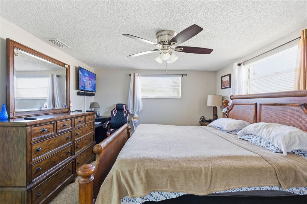 4904 Elmwood Street New Port Richey, FL 34653 - Photo 31 of 57 a bedroom with a bed and a chandelier