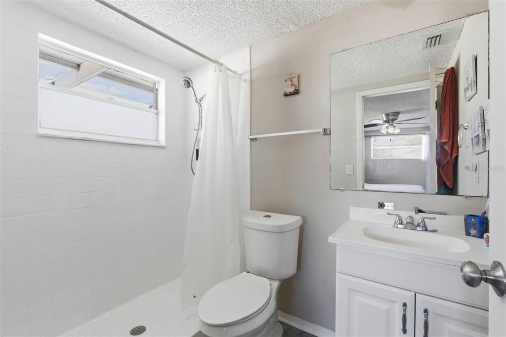 4904 Elmwood Street New Port Richey, FL 34653 - Photo 33 of 57 a bathroom with a sink a toilet and shower