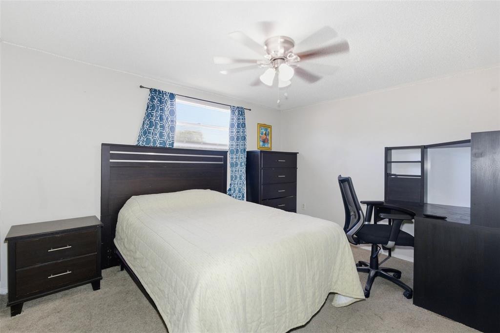 4904 Elmwood Street New Port Richey, FL 34653 - Photo 35 of 57 a bedroom with a bed and a chandelier