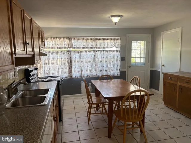 a kitchen with a table chairs sink and cabinets