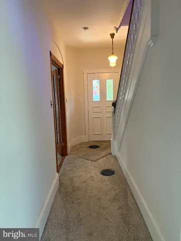 view of a hallway with wooden floor and a bathroom