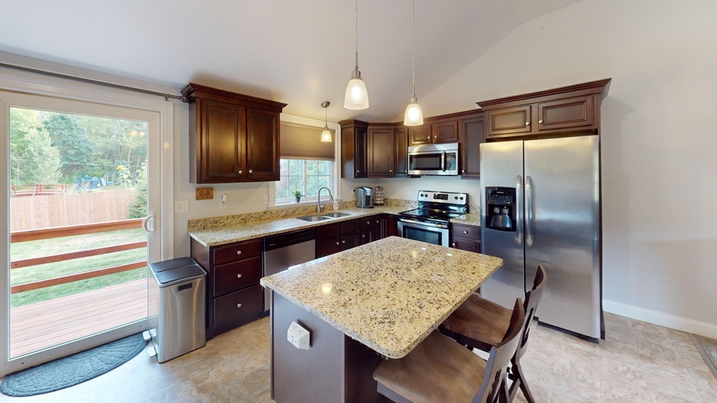 53 Walker Road Shirley, MA 01464 - Photo 15 of 29 a kitchen with a table chairs refrigerator and microwave