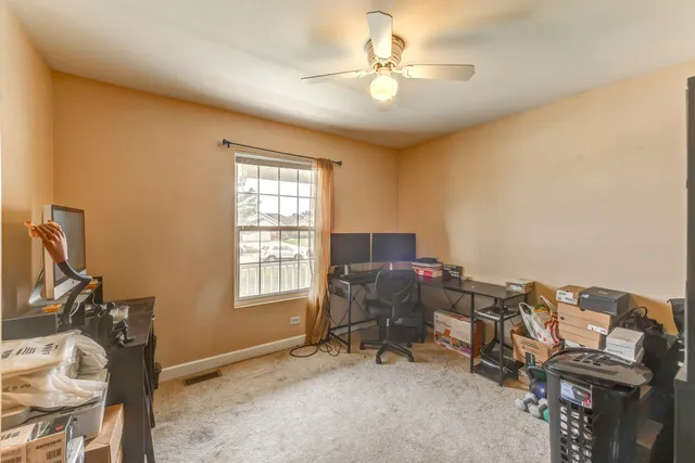 a view of a workspace with furniture and a window