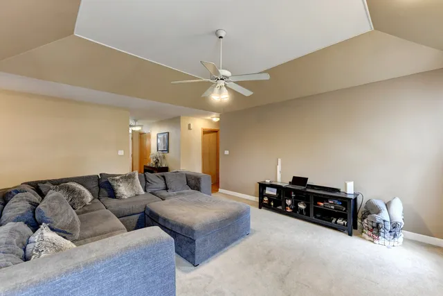 a living room with furniture and a ceiling fan