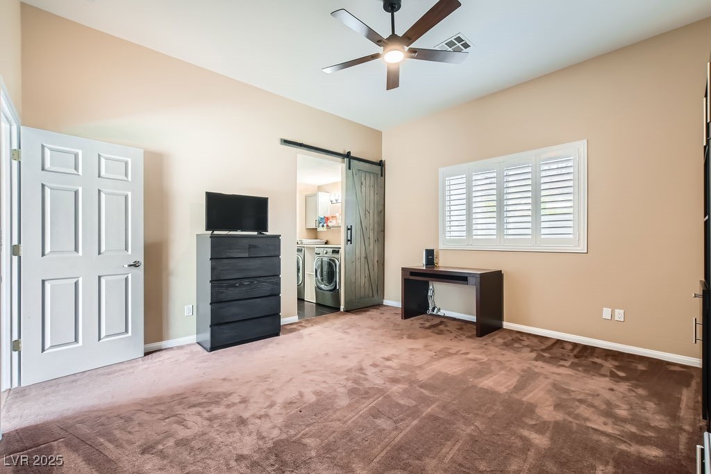 647 Foxhall Road Henderson, NV 89002 - Photo 33 of 82 Unfurnished bedroom with carpet floors, a barn door, baseboards, visible vents, and washer and dryer