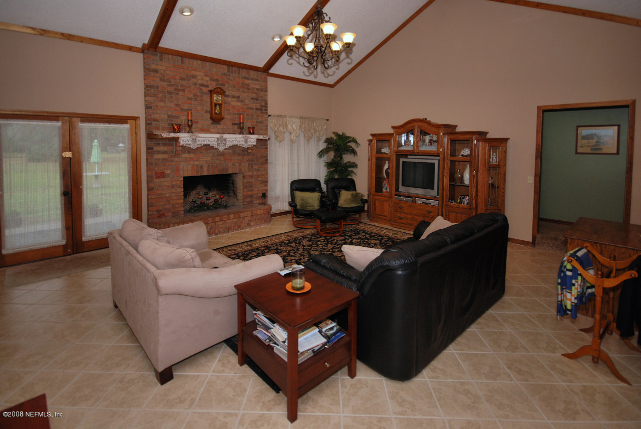 15591 Flounder Road Jacksonville, FL 32226 - Photo 6 of 12 a living room with furniture a chandelier and a fireplace
