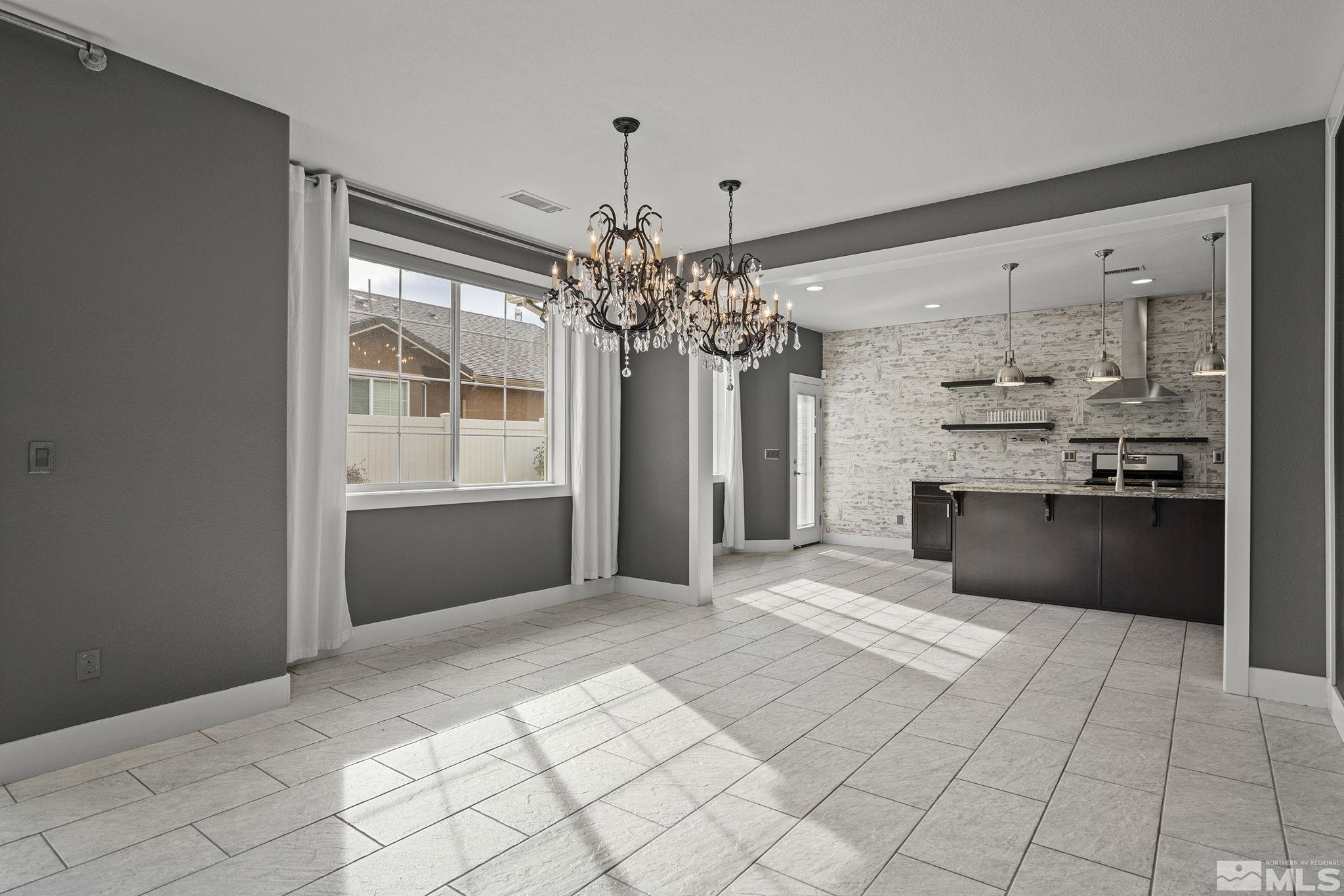 2230 Renzo Way Reno, NV 89521 - Photo 12 of 35 a kitchen with kitchen island granite countertop a refrigerator and a sink