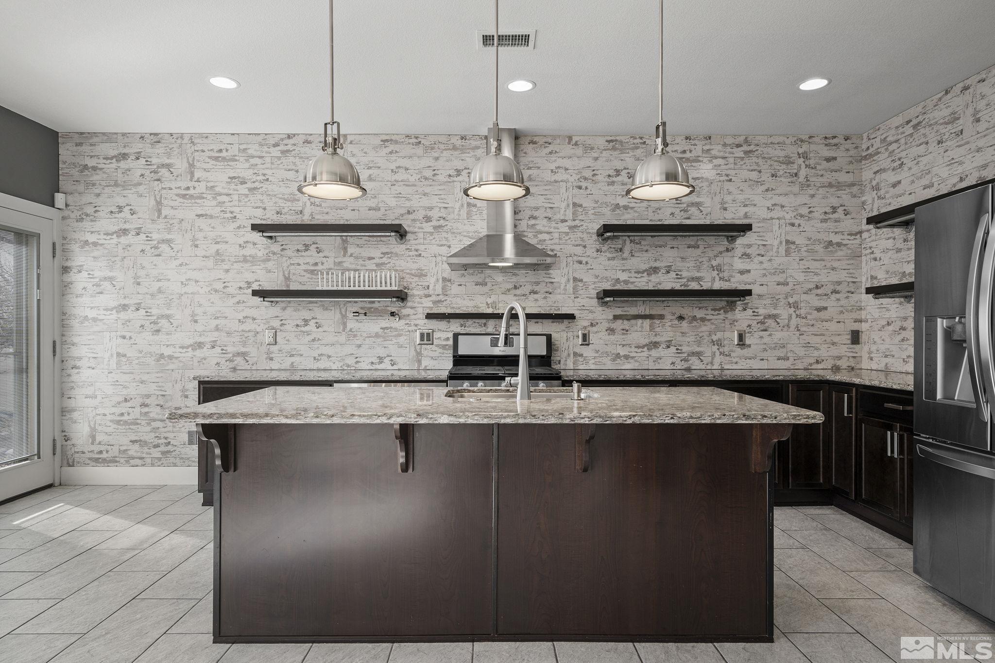2230 Renzo Way Reno, NV 89521 - Photo 13 of 35 a large kitchen with stainless steel appliances kitchen island a large island in the center