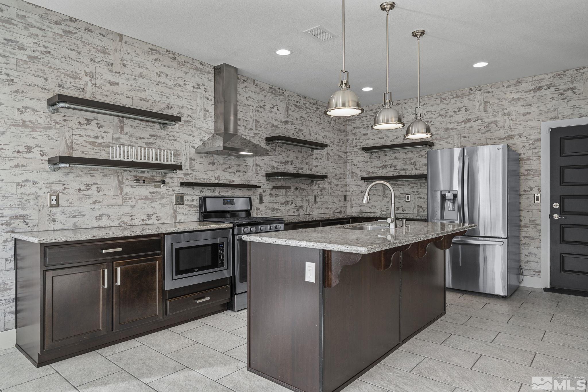 2230 Renzo Way Reno, NV 89521 - Photo 14 of 35 a kitchen with stainless steel appliances granite countertop a stove a sink and a refrigerator