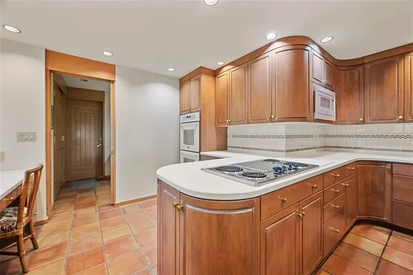 a kitchen with stainless steel appliances granite countertop a stove a sink and a refrigerator