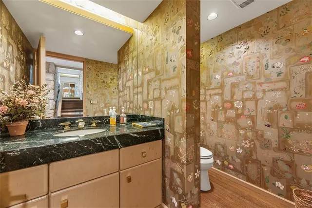 a bathroom with a granite countertop sink a mirror and shower