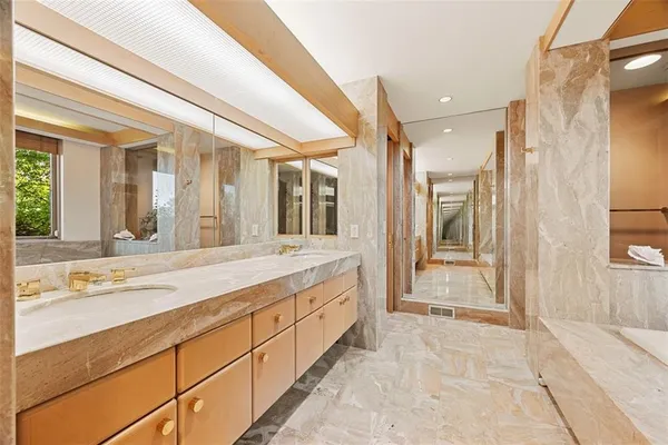 a bathroom with a tub shower and sink