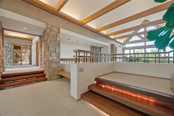 a spacious bedroom with a bed a table and large windows