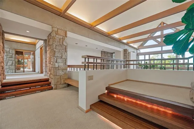 a spacious bedroom with a bed a table and large windows