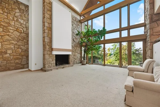 a view of an empty room with a fireplace and windows