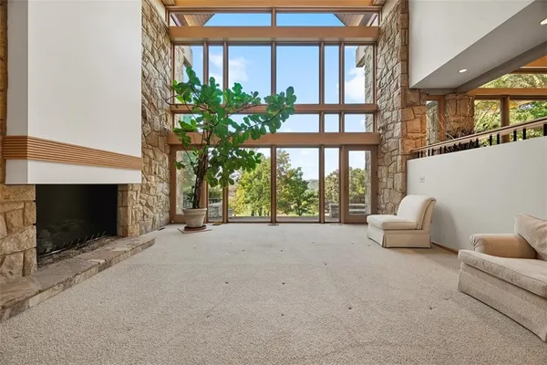 a living room with furniture a fireplace and a floor to ceiling window