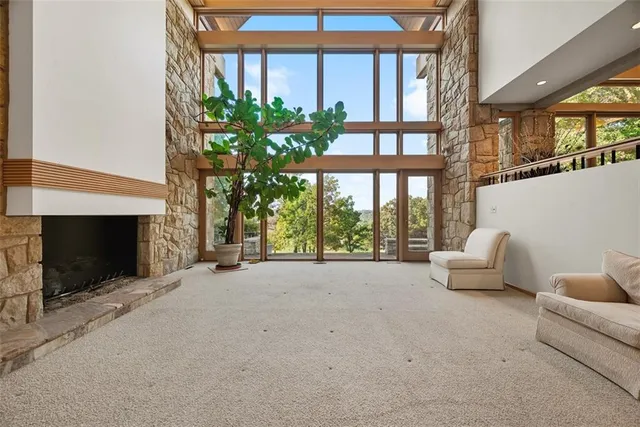 a living room with furniture a fireplace and a floor to ceiling window