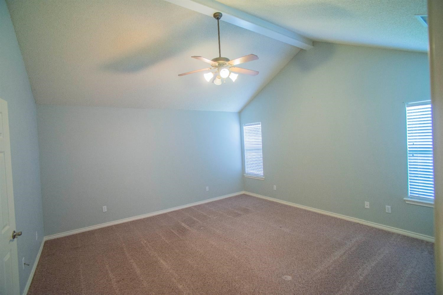 5502 103rd Street Lubbock, TX 79424 - Photo 11 of 15 en empty room with windows and chandelier fan
