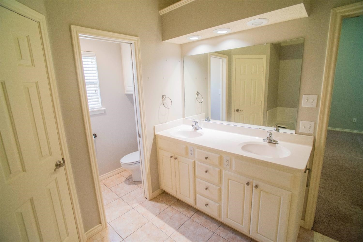 5502 103rd Street Lubbock, TX 79424 - Photo 13 of 15 a bathroom with a double vanity sink mirror and toilet