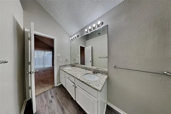 a bathroom with a granite countertop sink a mirror and a shower