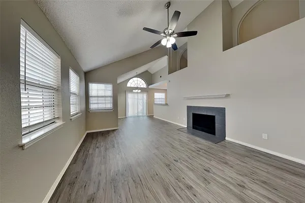 wooden floor fireplace and windows in an empty room