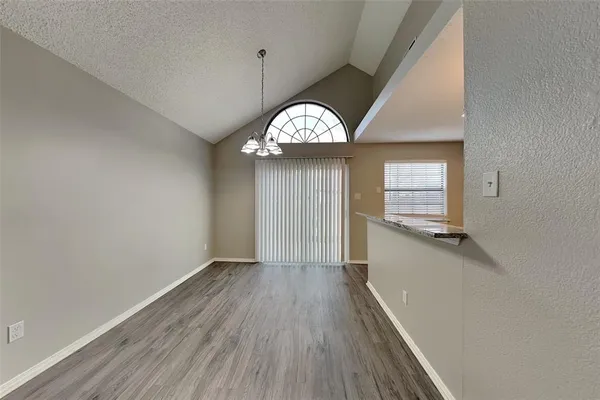a view of a hallway with wooden floor and a window