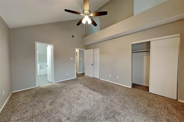 a view of an empty room and a ceiling fan