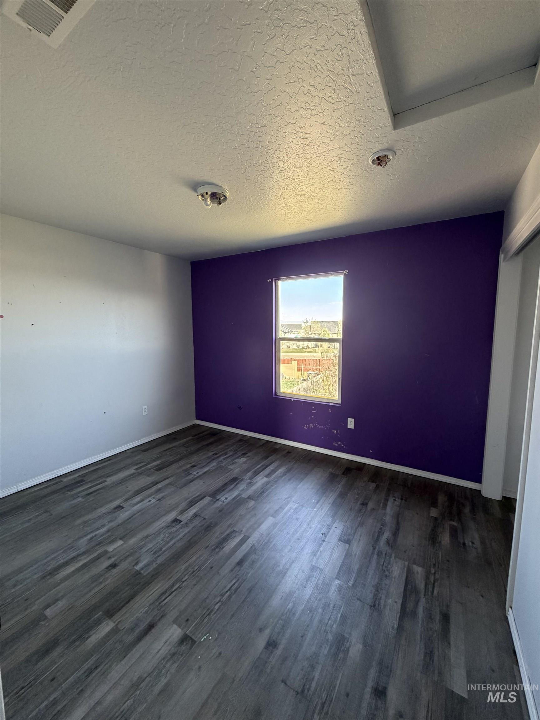 205 Middlepark Way Caldwell, ID 83605 - Photo 13 of 18 Spare room featuring a textured ceiling and dark wood-style floors