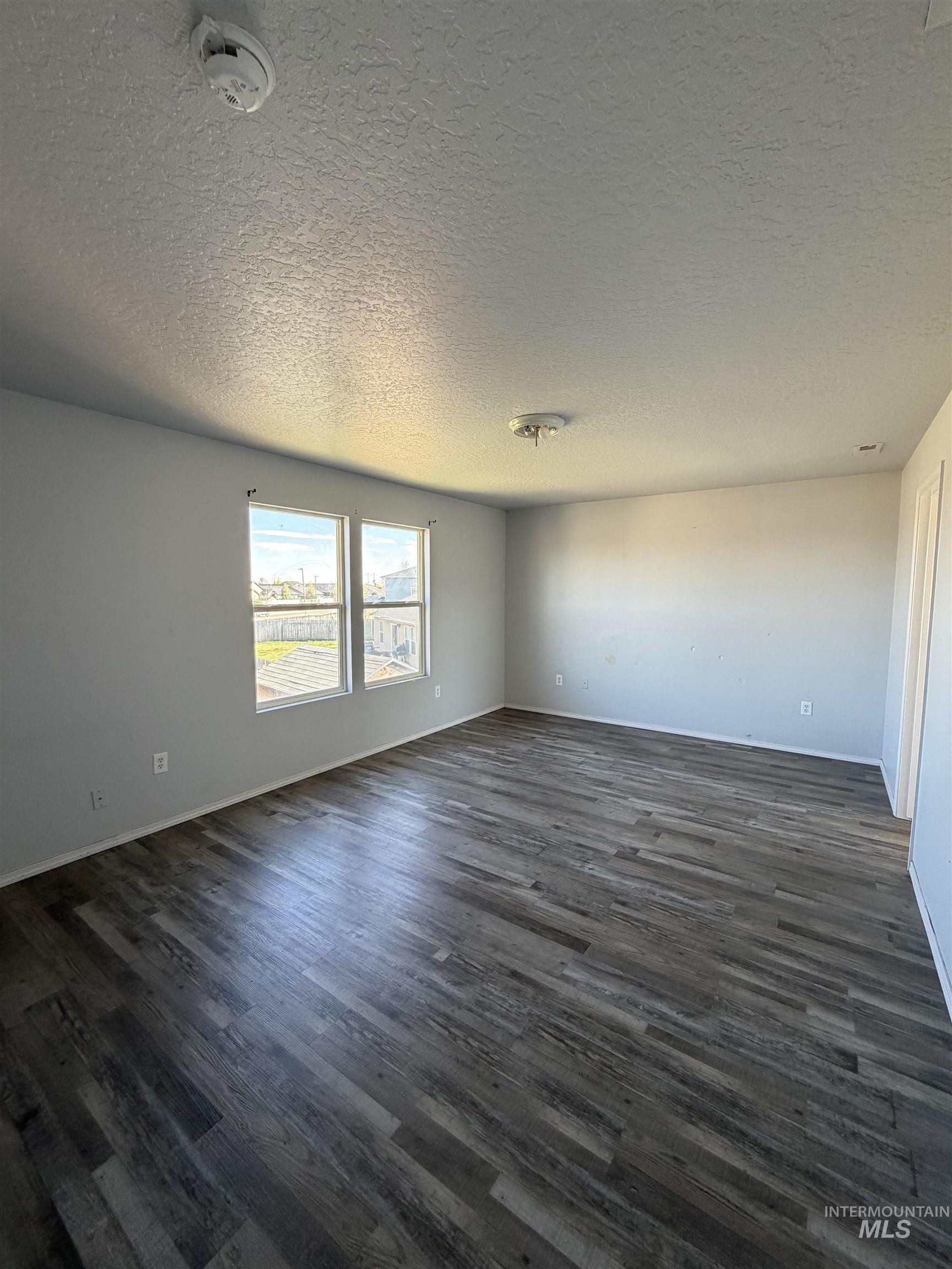 205 Middlepark Way Caldwell, ID 83605 - Photo 14 of 18 Unfurnished room featuring a textured ceiling and dark wood-style flooring