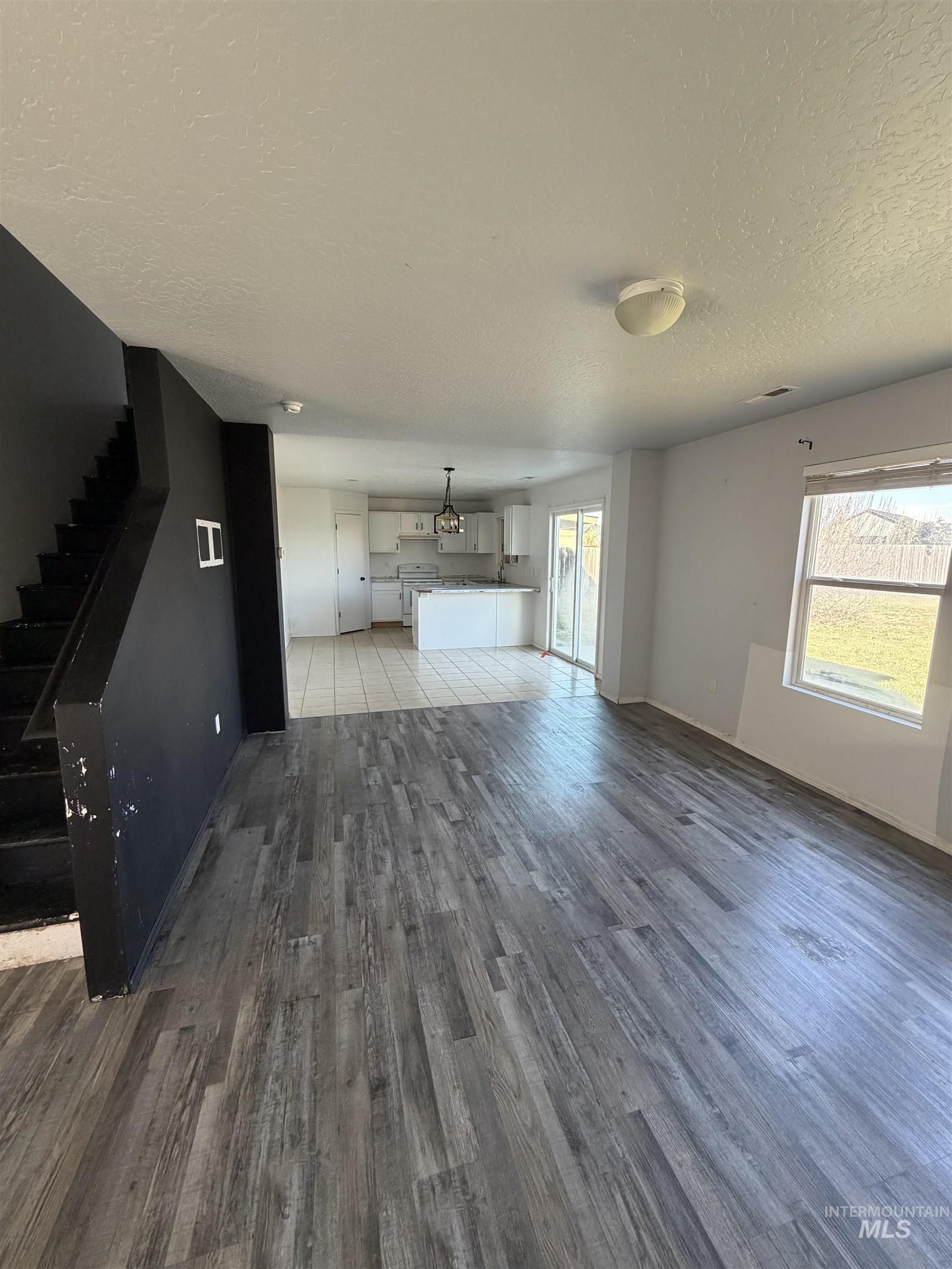 205 Middlepark Way Caldwell, ID 83605 - Photo 6 of 18 Unfurnished living room featuring a textured ceiling and light wood finished floors