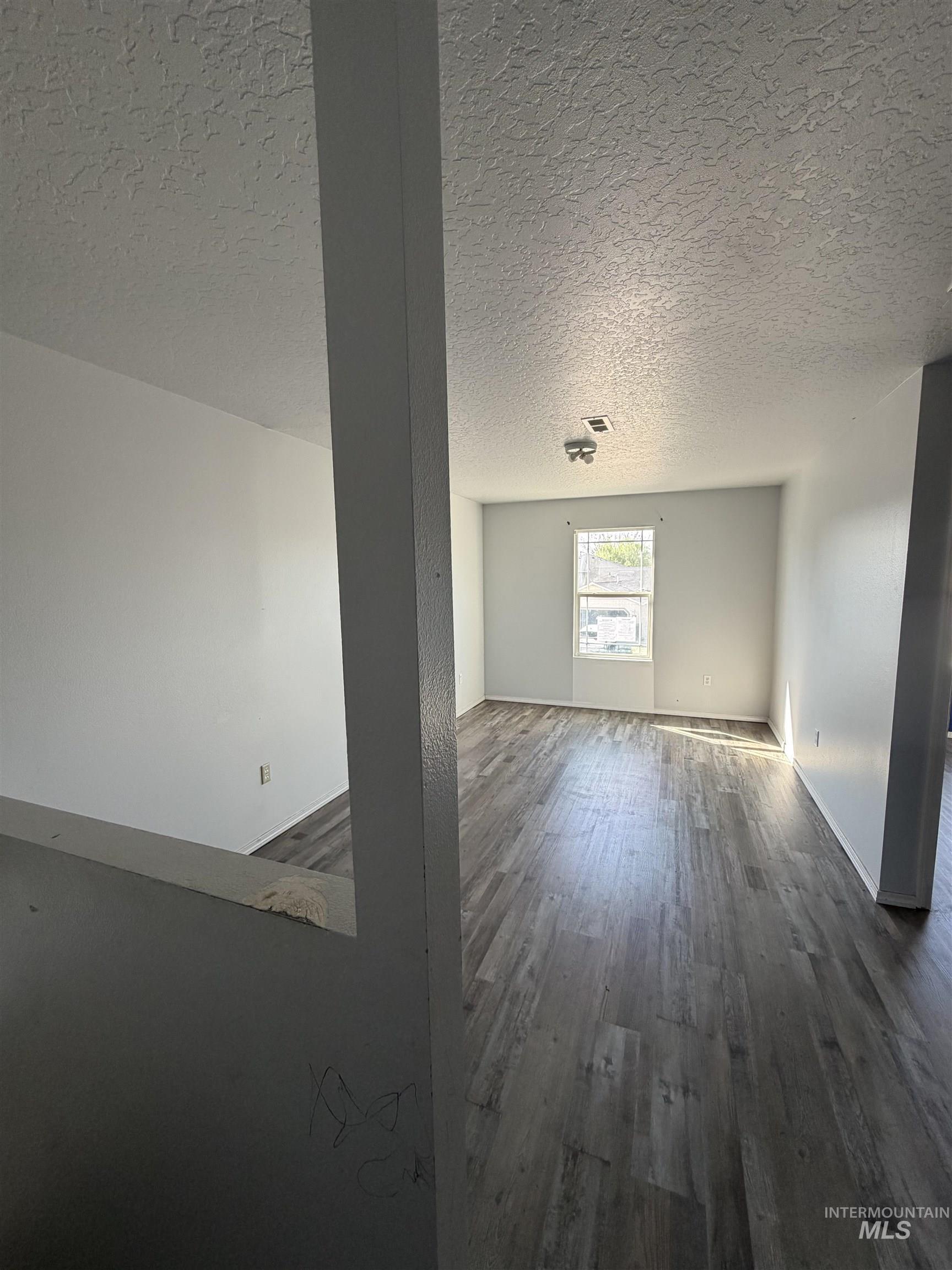 205 Middlepark Way Caldwell, ID 83605 - Photo 9 of 18 Spare room with dark wood-style floors and a textured ceiling