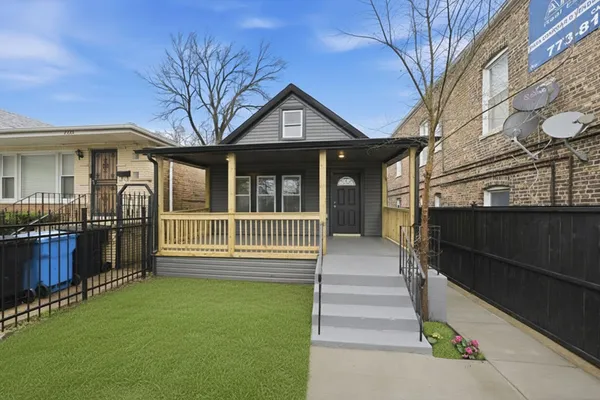a view of a house with a small yard and wooden fence