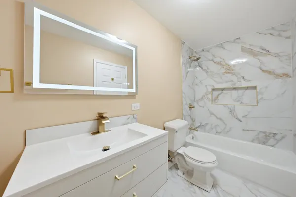 a bathroom with a sink a toilet and shower