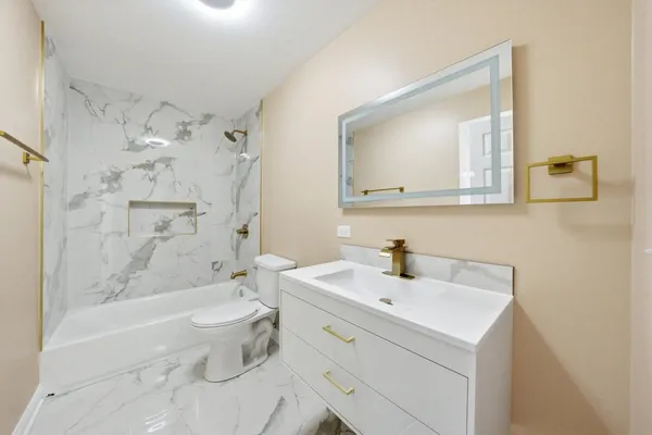 a bathroom with a sink a toilet and shower
