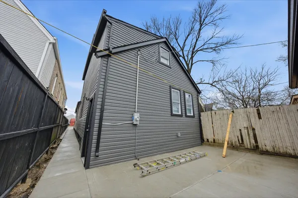 a house with a tree and wooden fence