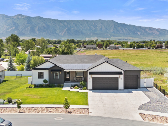 3111 South 1250 West Logan, UT 84321 - Photo 45 of 51 Contemporary single-story residence featuring a dark gray roofline and a two-tone exterior with white board and batten siding and dark gray horizontal siding