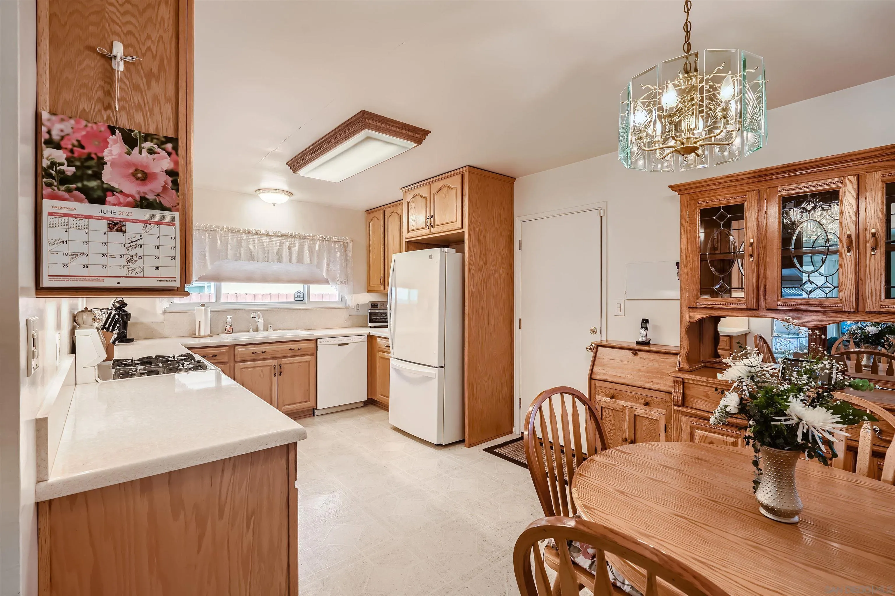 577 Cedar Street El Cajon, CA 92021 - Photo 3 of 11 a kitchen with stainless steel appliances granite countertop a dining table and chairs with wooden floor