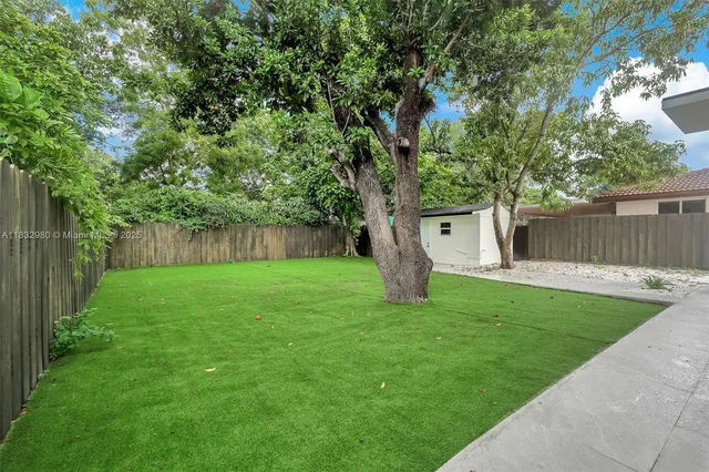 a view of a back yard with a tree