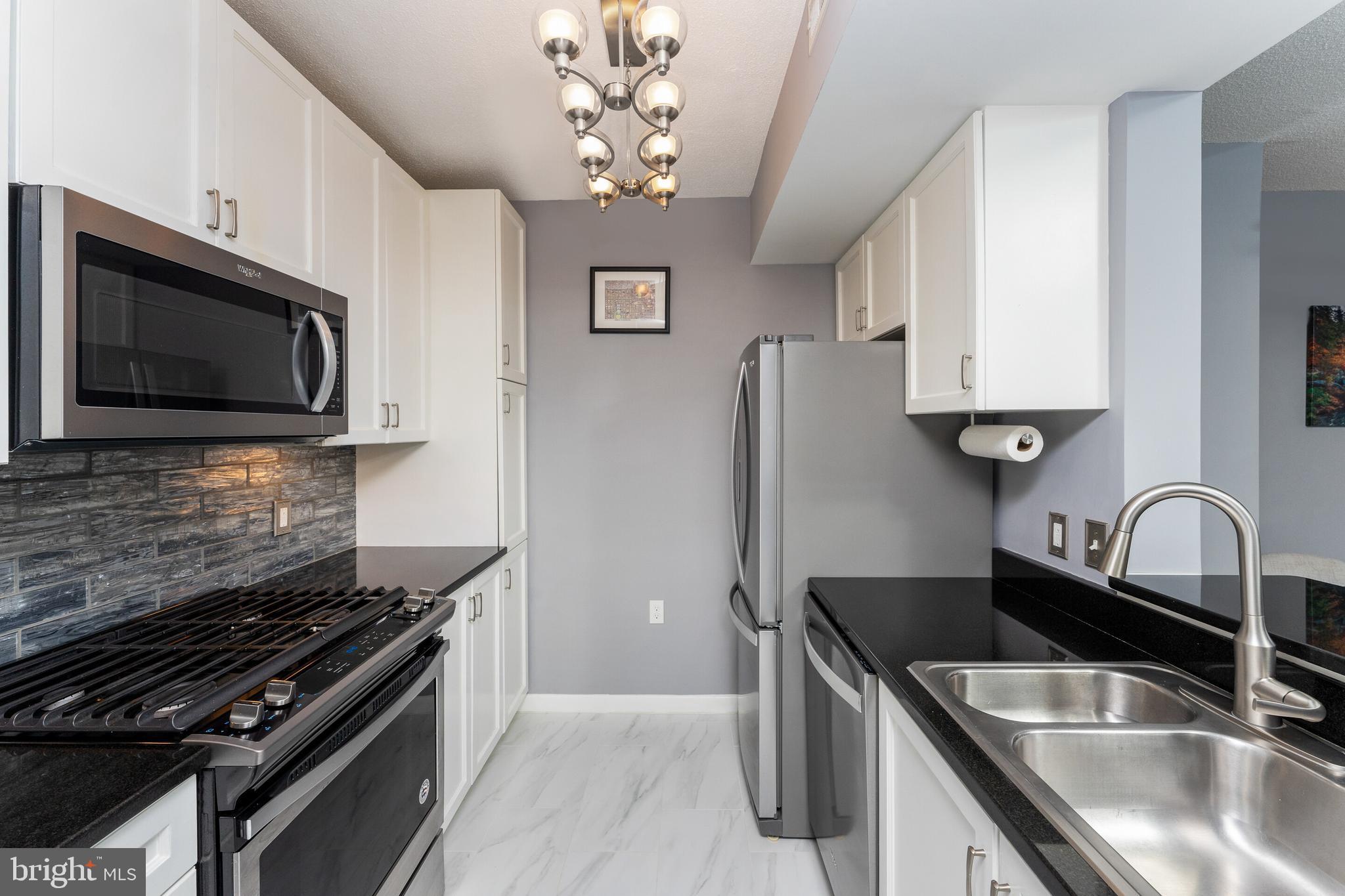 851 North Glebe Road, Unit 1818 Arlington, VA 22203 - Photo 4 of 23 a kitchen with stainless steel appliances granite countertop a sink stove and microwave